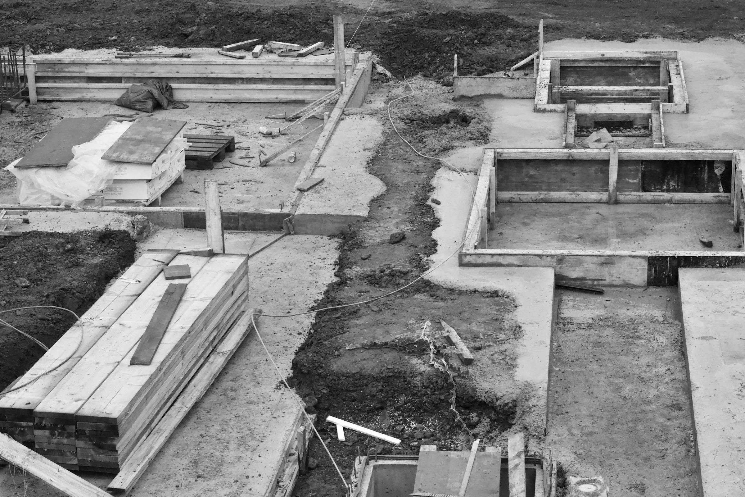 Schwarz-Weiß-Luftaufnahme einer Beton-Fundament-Baustelle mit Bewehrungsraster, Sinnbild für solide Digitalisierungsbasis vor KI